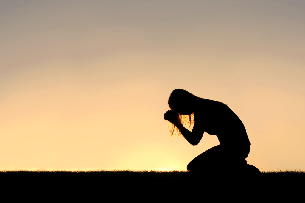 christian-woman-sitting-down-in-prayer-silhouette-the-broken-assembly